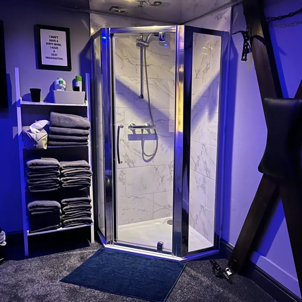 Larger specialist room with BDSM cross, floggers and en-suite shower at Ladybirds Manchester