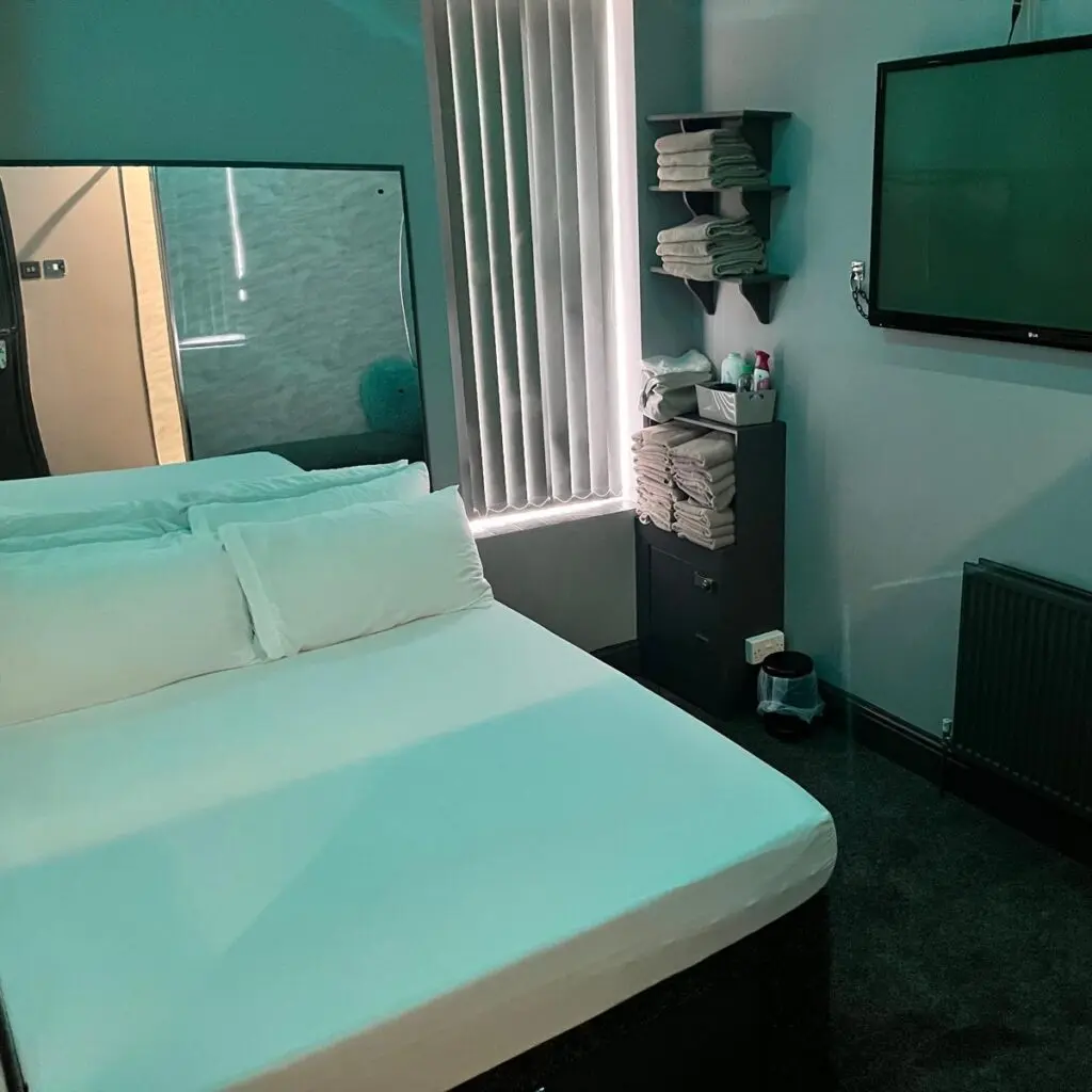 Themed guest room with fresh towels and wall TV at Ladybirds Manchester