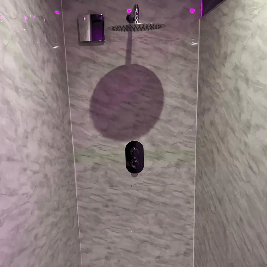 En-suite rainfall shower with marble-effect walls at Ladybirds Manchester