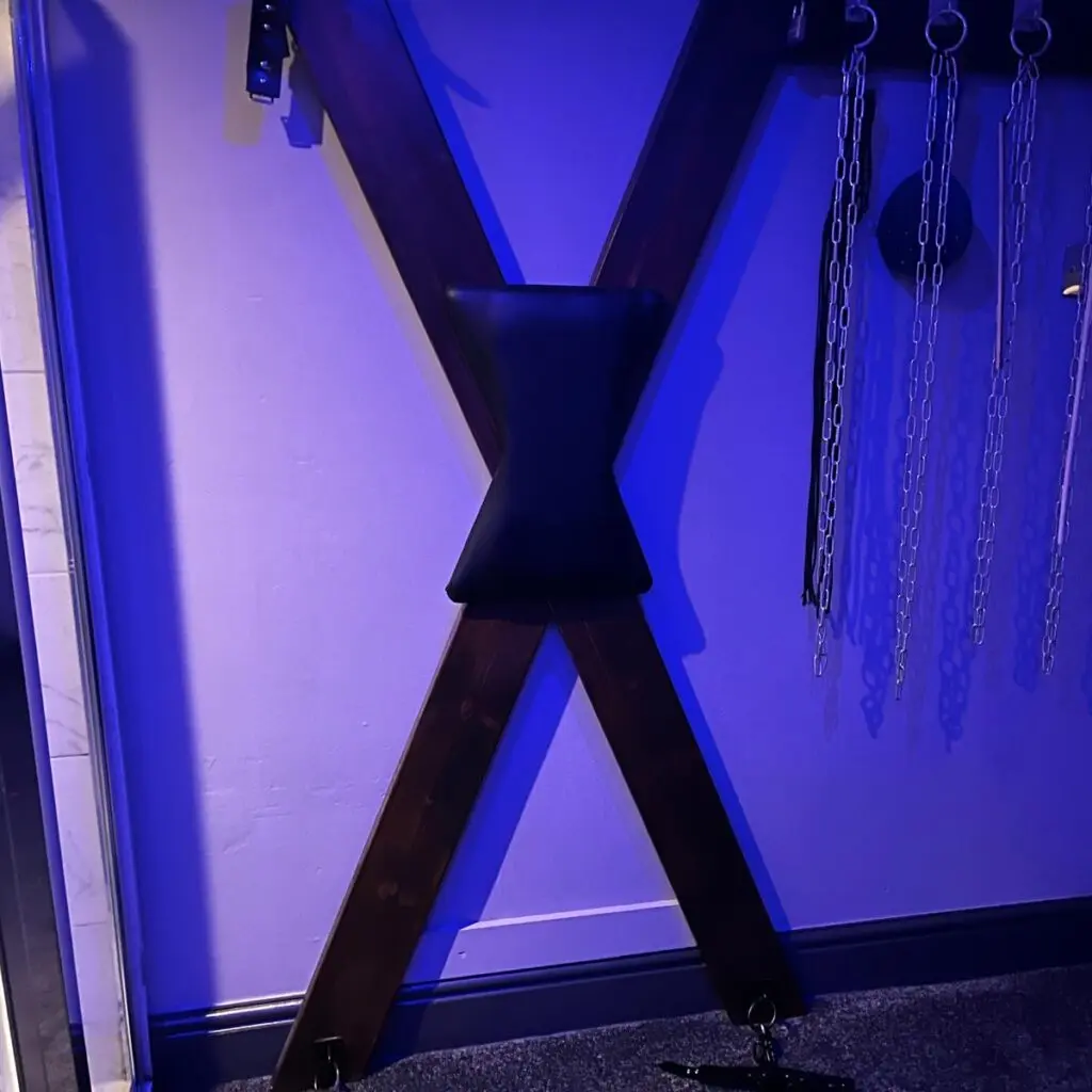 Specialist room with BDSM cross and equipment at Ladybirds Manchester
