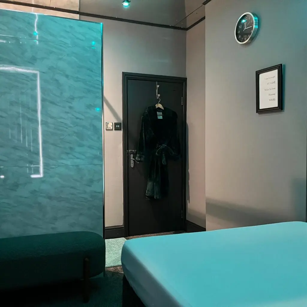 Massage room with treatment couch and robe at Ladybirds Manchester