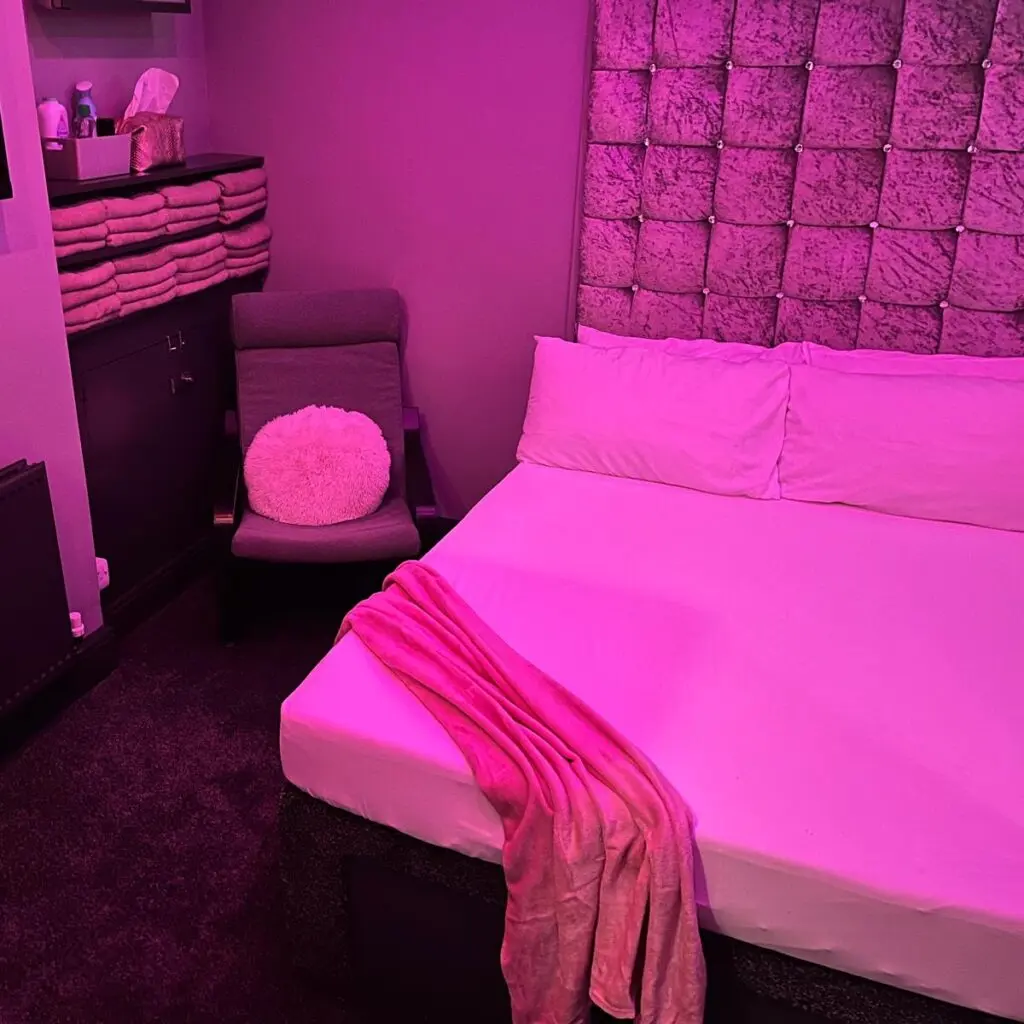 Themed pink guest room with padded headboard and wall TV at Ladybirds Manchester