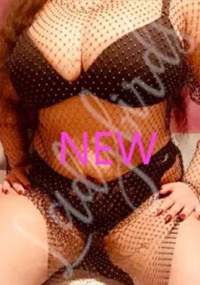 Person wearing black rhinestone lingerie set with fishnet mesh overlay.